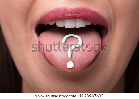 Close-up Of A Woman's Tongue With White Question Mark Sign