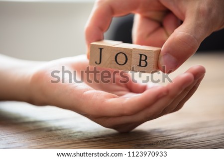 Close-up Of Businessperson's Hand Giving Wooden Block With Job Text To Candidate Royalty-Free Stock Photo #1123970933