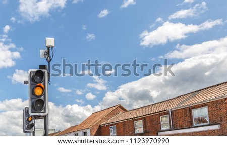View of a traffic light illuminated in yellow in the middle of a small English town, UK