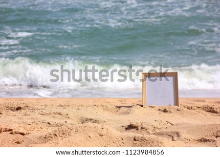 Wooden picture frame on the beach sand, Copy space,summer concept.