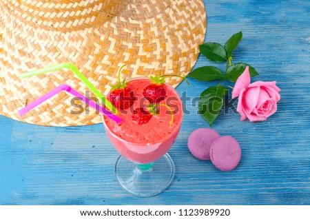 Summer concept. Straw hat, smoothies on blue background. Studio Photo