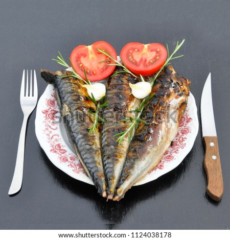Fish in vegetable sauce on a black wooden background.