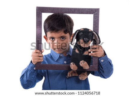 Portrait of a boy holding stuffed toy pet with frame.