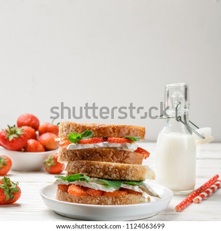 Sandwiches with brie or Camembert cheese, strawberries and mint. Delicious breakfast. Selective focus. square picture, copy space