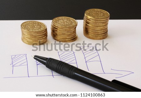 Sales and financial business graph - hand drawn with ball pen on white paper and piles of golden money coins showing profits and gains in successful corporate teams - with copy space for writing