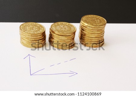 Sales and financial business graph - hand drawn with ball pen on white paper and piles of golden money coins showing profits and gains in successful corporate teams - with copy space for writing