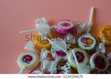 colorful fruit lollipops on a pink background, unhealthy but delicious snack for children, sweets