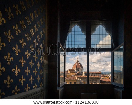 View of dome of Florence Cathedral over houses of historic centre of Florence, from a room of Palazzo Vecchio, with Fleur-de-lis pattern on wall, in Florence, Italy Royalty-Free Stock Photo #1124136800