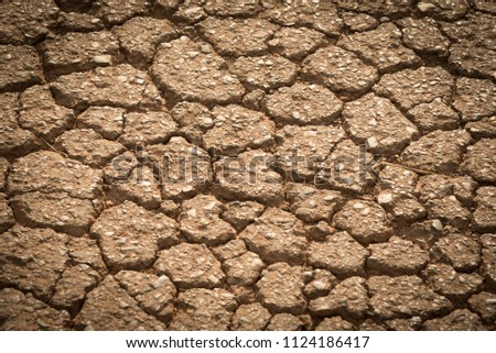 top view cracked red soil ground Earth for texture background,desert cracks,Dry Orange surface Arid,drought land,Picture of natural disaster. drought land Caused by global warming and deforestation