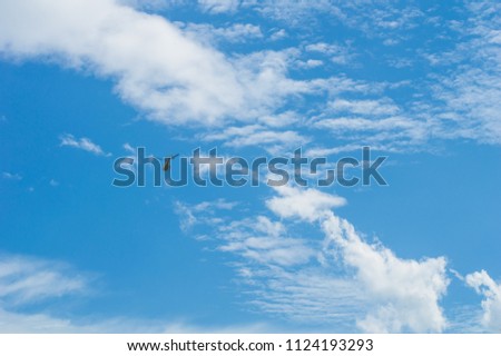 Helicopter flies against a background of white  clouds in a blue sky.Helicopter in a blue sky and clouds.