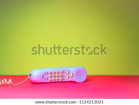 telephone with cord on yellow and pink background isolated candy colors