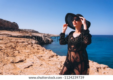 Woman standing on rocks by the sea