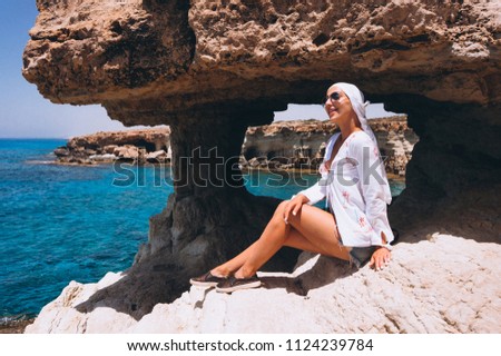 Woman sitting on the rocks top by the ocean