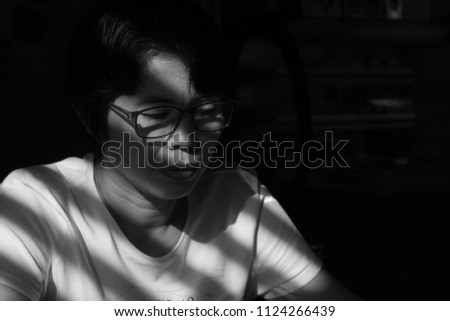 Black-and-white picture of middle-aged Asian women sitting down to think about something.