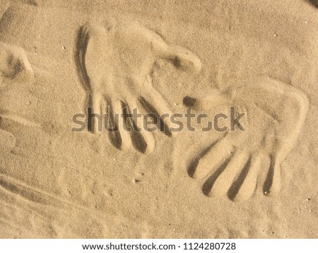 playing with sand on the beach ( two hands shape )