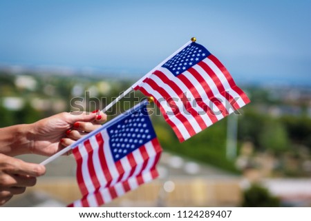 Woman hands with USA national flag celebrating american national holiday like 4ht of July, Flag day, national day or memorial day.
