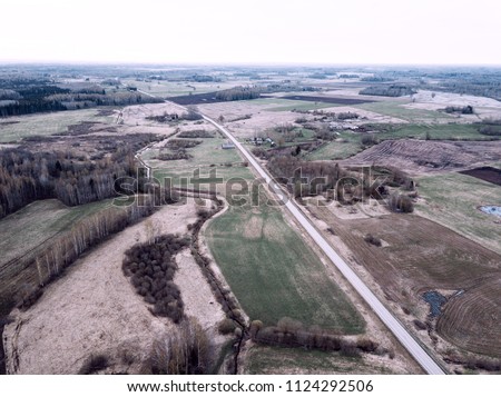 drone image. aerial view of rural area with gravel road network cloudy spring day. latvia - vintage film look