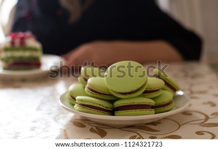 Pistachio Macaroons on a table, women on a backcround.Copy Space Card, Sweet Tasty Macaroons
