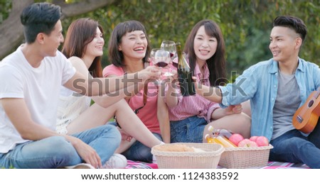 Friends go picnic together in the park and enjoy the food and drink