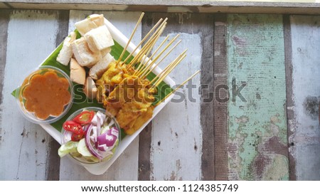 Pork Satay popular Thai food. Picture Pork satay with toast and bean sauce and salad put on a wooden table.Has space for writing text.Take pictures from the top. Bird’s eye view