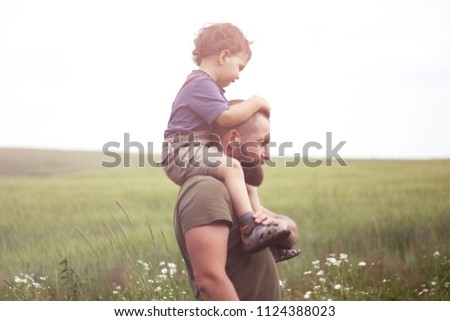 the child sits on the shoulders of his father