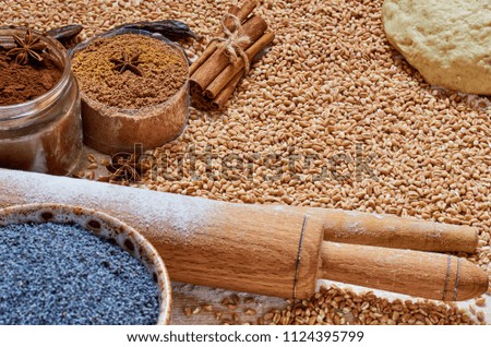 Raw igredients for cooking bread or cake (eggs, spices, flour, poppy seeds, grains, rolling pin). Baking background. Kitchen rustic wooden table with bakery supplies. Side view