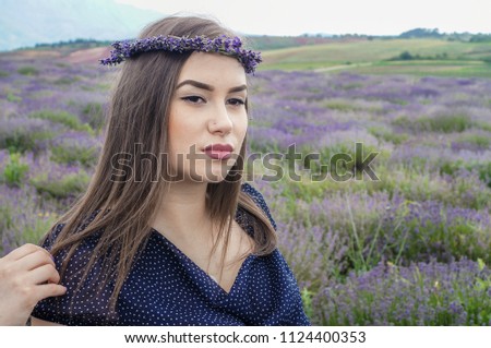 Girls with lavender wreaths walk in the lavender field