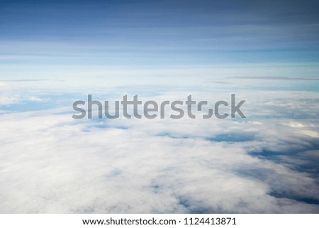 Beautiful blue sky, above white clouds and sky line, view from airplane window. Bird eye view. Dreamy, fresh air, natural background for travel, vacation and presentation theme backdrop.