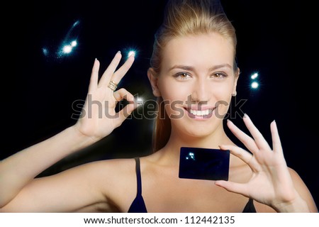 Portrait of confident woman with business card against night sky
