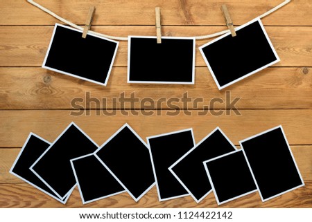 Blank instant photo frames on brown wooden background.