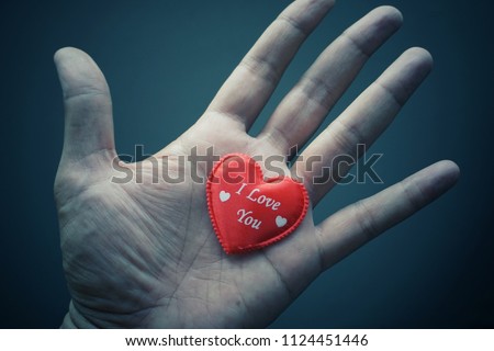Hand holding the red heart symbol with word I Love You. Soft and vintage background image.