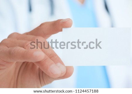 Male doctor or medical worker showing business card with blank space for text closeup.