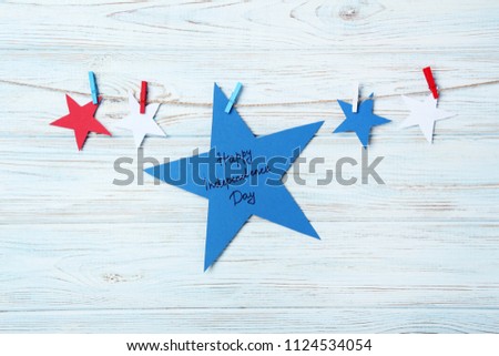 Paper star with inscription Happy Independence Day on wooden background