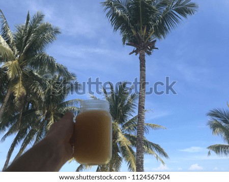 Orange juice in front of palm trees on Alona Beach, Bohol, Visayas, Philippines