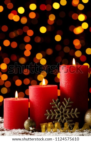 Christmas candles with baubles and snowflake on lights background