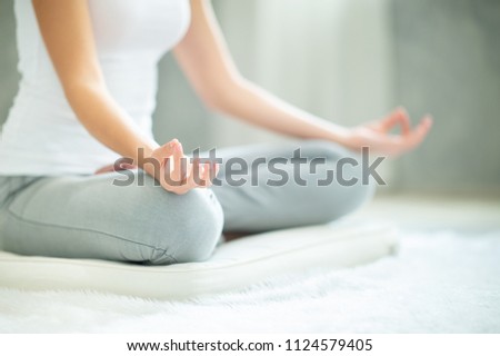 Young attractive smiling woman practicing yoga, sitting in Half Lotus exercise, Ardha Padmasana pose, working out, wearing sportswear, meditation session,Time for yoga