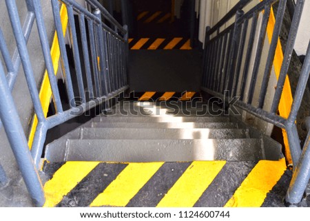 Emergency stairs inside ferry boat with yellow and black stripe background. Texture yellow and black diagonally stripes. Yellow and black stripes sign of danger.