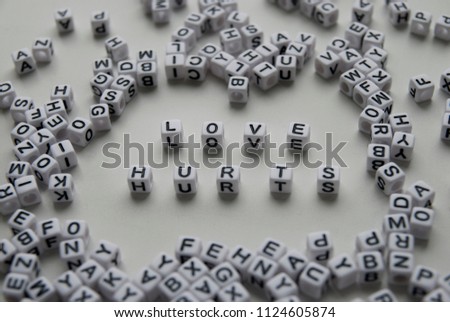 love hurts word written on cubes on white background. Creative text for your business. Chaotic letters design.