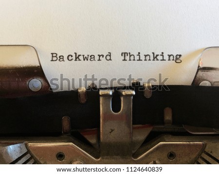 Backward Thinking, title heading typewritten on white paper on vintage manual typewriter machine