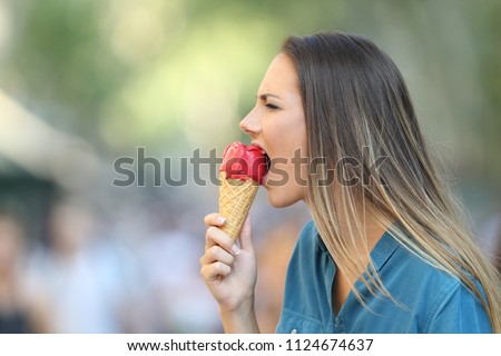 Side view portrait of a woman with hypersensitivity biting an ice cream Royalty-Free Stock Photo #1124674637
