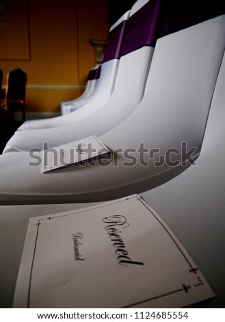 Reserved signs on the reserved chairs, Hitchin, England. These white decorated chairs are part of weddings ceremony and there are reserved for some special guests 