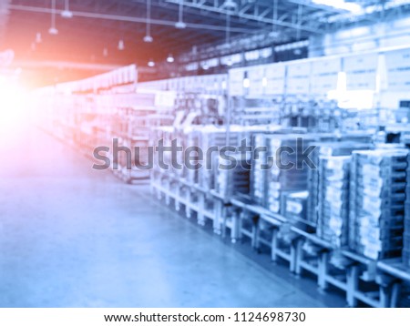 Blurry background of warehouse and storage. Abstract of business concept. Logistics and industrial theme. Blue tone and orange sun light element