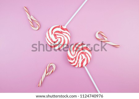 Flat lay top view tasty appetizing concept, minimal Sweet Treat Swirl Candy Lollipop marshmallow Colorful pattern on pink pastel background and copy space