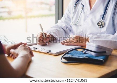 The doctor is discussing with the patient after a physical examination of the results and treatment guidelines. Royalty-Free Stock Photo #1124741063