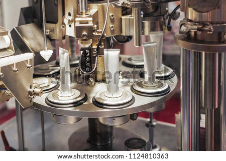 Automatic machine for filling tubes. Modern equipment for the production of cosmetics. Royalty-Free Stock Photo #1124810363