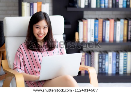 Beautiful of portrait asian young woman freelance working online laptop sitting on chair at living room, girl using notebook computer with connect to internet for distance job, business concept.