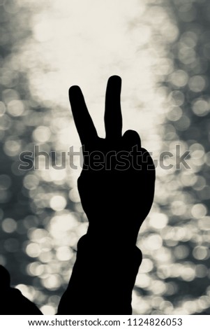 Beautiful silhouette victory hand sign unique black and white photo
