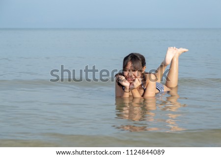 Asia teenage girls wearing bikini at the beach with copy space.
