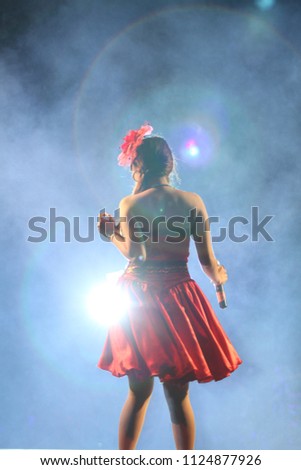 Young girl dancing isolated attire red dress on black background. Rim light my hair caused by light shining from the front.