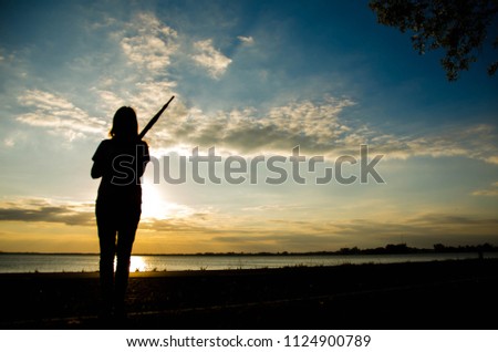 Sad woman standing on the road with sunset background.